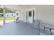 Inviting front porch featuring neutral paint, chairs, table, and a clear view of the front yard at 9413 Forest Hills Dr, Tampa, FL 33612