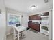 Functional kitchen featuring a white table with seating, dark cabinets, and modern appliances at 9413 Forest Hills Dr, Tampa, FL 33612