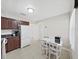 Bright kitchen with tile floors, dark wood cabinets, stainless steel appliances, and a small dining table at 9413 Forest Hills Dr, Tampa, FL 33612
