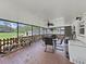 The screened-in patio features wood flooring and a ceiling fan, perfect for outdoor dining at 9413 Forest Hills Dr, Tampa, FL 33612