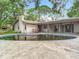Exterior backyard view featuring a kidney-shaped pool and covered porch for entertainment at 950 Waverly St, Oldsmar, FL 34677