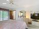 Spacious bedroom with a ceiling fan, walk-out patio access, and view into the attached bathroom at 950 Waverly St, Oldsmar, FL 34677