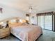 Light bedroom with a large bed, ceiling fan, and access to an outdoor patio or screened-in area at 950 Waverly St, Oldsmar, FL 34677