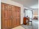 A view of the entryway with a wooden double door, leading to a living space with carpet and a window at 950 Waverly St, Oldsmar, FL 34677