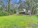 Back exterior features a screen enclosure, lush greenery and large yard with mature trees at 950 Waverly St, Oldsmar, FL 34677