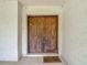 A close-up view of a beautiful wooden double door entryway with textured walls and a welcome mat at 950 Waverly St, Oldsmar, FL 34677