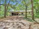 View of the house's back side featuring an open garage with lots of storage and a spacious yard at 950 Waverly St, Oldsmar, FL 34677