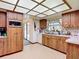 Well-lit kitchen with wood cabinets and laminate countertops. Has white appliances, enhancing its classic charm at 950 Waverly St, Oldsmar, FL 34677