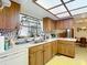 View of kitchen with wood cabinets and laminate countertop plus a window and a stainless steel sink at 950 Waverly St, Oldsmar, FL 34677