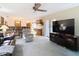 Open-concept living room features a kitchen view, a ceiling fan, and sliding glass doors at 950 Waverly St, Oldsmar, FL 34677