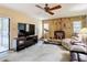 Cozy living room features a stone fireplace, ceiling fan, and sliding glass door to the backyard at 950 Waverly St, Oldsmar, FL 34677