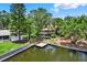 Aerial view of a home with a private dock, spacious backyard, and lush greenery, offering waterfront living at 10732 Drummond Rd, Tampa, FL 33615