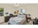 Comfortable bedroom with a vintage desk, ceiling fan, and a patchwork quilt at 10732 Drummond Rd, Tampa, FL 33615
