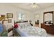 Cozy bedroom with wood furniture, ceiling fan, a patterned quilt, and access to the outdoors at 10732 Drummond Rd, Tampa, FL 33615