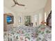 Spacious bedroom with large windows, floral quilt, and a TV in a custom armoire at 10732 Drummond Rd, Tampa, FL 33615