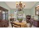 Classic dining room with traditional chandelier, cabinet, and a large arched window at 10732 Drummond Rd, Tampa, FL 33615