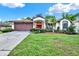 Charming single-story home features a beautiful red front door and a well-manicured lawn at 10732 Drummond Rd, Tampa, FL 33615