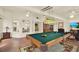 This game room features a stylish pool table, unique lighting, and bright windows at 10732 Drummond Rd, Tampa, FL 33615