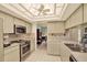 Well-lit kitchen featuring tile floors, stainless steel appliances, and lots of cabinetry at 10732 Drummond Rd, Tampa, FL 33615