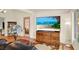 Living room features wood floors, a decorative lamp, and a flat screen TV on a dresser at 10732 Drummond Rd, Tampa, FL 33615