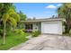 Well-maintained single-story home with an attached garage, complemented by lush tropical landscaping at 1084 39Th Ne Ave, St Petersburg, FL 33703