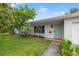 Charming single-story home featuring a quaint, light-blue front door and lush, mature landscaping at 1084 39Th Ne Ave, St Petersburg, FL 33703