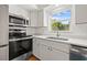 This kitchen offers stainless steel appliances, white cabinetry, and quartz countertops for a modern look at 1084 39Th Ne Ave, St Petersburg, FL 33703