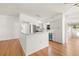 Bright kitchen with white cabinetry, stainless appliances, and adjacent dining area featuring hardwood floors at 1084 39Th Ne Ave, St Petersburg, FL 33703