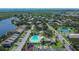 Aerial view showcasing the community, pool, playground, mature trees, and nearby lake at 110 114Th Ne Ter # 110, St Petersburg, FL 33716