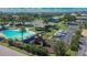 Aerial view of community amenities: a pool, playground, tennis court, parking, and lush landscaping at 110 114Th Ne Ter # 110, St Petersburg, FL 33716