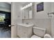 Bright bathroom featuring a white vanity, mirrored medicine cabinet, and a clean, well-maintained toilet at 110 114Th Ne Ter # 110, St Petersburg, FL 33716