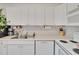This efficient kitchen features white cabinetry, a dishwasher, and modern appliances for a functional cooking area at 110 114Th Ne Ter # 110, St Petersburg, FL 33716