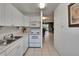 Efficient kitchen setup with white cabinets, microwave, stove, and tile flooring at 110 114Th Ne Ter # 110, St Petersburg, FL 33716