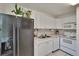 Well-equipped kitchen with white cabinets, essential appliances, and durable tile flooring for functional cooking space at 110 114Th Ne Ter # 110, St Petersburg, FL 33716