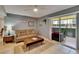 Cozy living room features neutral tones, tile flooring, and sliding glass doors to a screened in patio at 110 114Th Ne Ter # 110, St Petersburg, FL 33716