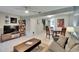 Spacious living room boasts a TV, shelving unit, and open access to a dining room and staircase at 110 114Th Ne Ter # 110, St Petersburg, FL 33716