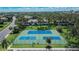 Aerial view of dual tennis courts at a community complex, surrounded by trees and greenery at 110 114Th Ne Ter # 110, St Petersburg, FL 33716