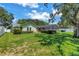 A lovely backyard view of the home and the screened in pool area with a well manicured lawn at 11250 Tradewinds Blvd, Largo, FL 33773