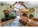 Open living room with brick fireplace, exposed beams, TV, and sitting area at 11250 Tradewinds Blvd, Largo, FL 33773