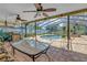 Enclosed patio with ceiling fans, a grill, ample dining and seating area that overlooks a beautiful pool at 11250 Tradewinds Blvd, Largo, FL 33773