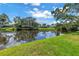 Tranquil pond reflecting the sky and trees in the backyard offering privacy and a calming presence at 11250 Tradewinds Blvd, Largo, FL 33773