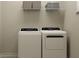 Functional laundry room equipped with a washer, dryer, and overhead storage shelves at 11518 Flourish Dr, Land O Lakes, FL 34637