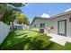 Backyard with putting green, artificial grass, blue shed and the rear of the house at 11763 Saree Ct, Largo, FL 33778