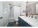 Beautiful bathroom with blue vanity, modern fixtures, white horizontal paneling, and shower-tub with marble tile at 11763 Saree Ct, Largo, FL 33778