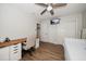 Bright bedroom features wood-look tile floors, desk with storage, ceiling fan, closet and TV on wall at 11763 Saree Ct, Largo, FL 33778