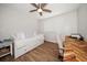 Bright bedroom with white walls, a ceiling fan, a day bed, wood-look tile floors and desk at 11763 Saree Ct, Largo, FL 33778