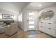 Bright entryway with wood floors, modern shoe storage, and a decorative round mirror at 11763 Saree Ct, Largo, FL 33778