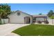 Charming single-story home featuring a two-car garage, pergola, and well-manicured front lawn at 11763 Saree Ct, Largo, FL 33778