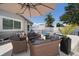 Outdoor patio features wicker seating under umbrella, overlooking pool and white privacy fence at 11763 Saree Ct, Largo, FL 33778