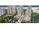 Aerial view displays beachfront condos, parking, mature landscaping, and tennis courts close to beach at 1180 Gulf Blvd # 504, Clearwater Beach, FL 33767